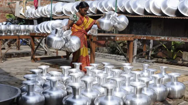 அலுமினிய பாத்திர வேலை செய்யும் பெண்