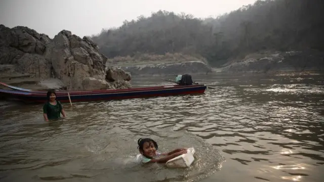 เด็กสาวเล่นน้ำในแม่น้ำ