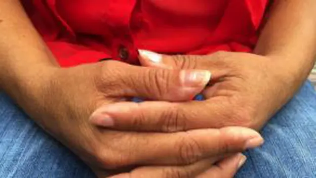 Manos entrelazadas de una mujer