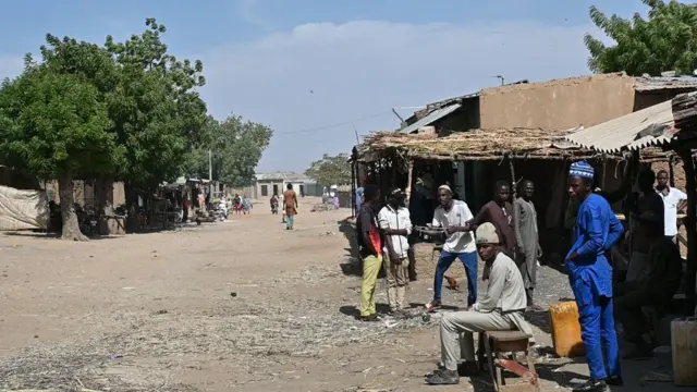 Des hommes debout le long d'un chemin de terre