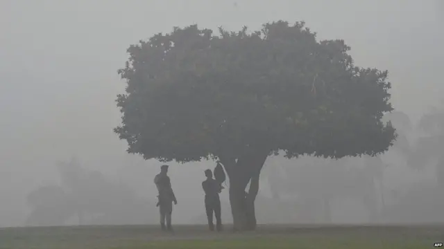 Indian security personnel stand guard at the Rajghat memorial amid heavy smog in New Delhi on November 7, 2017.