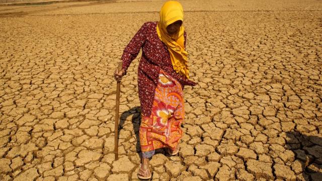 Mujer caminando sobre terreno seco en Indonesia