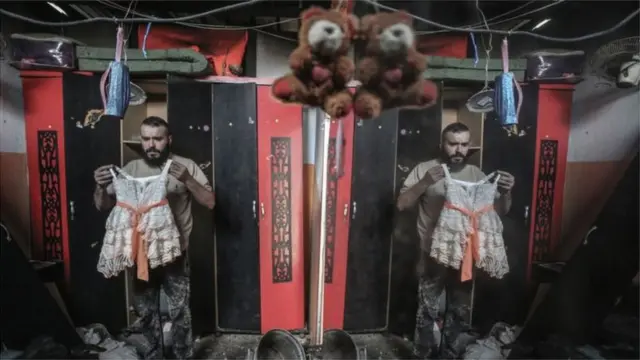 ગાઝામાં પોતાની દુકાન વ્યવસ્થિત કરતા એક દુકાનદાર