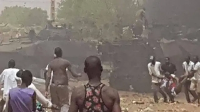 Des civils accourent sur les lieux de l'explosion avec un blessé évacué par des bonnes volontés.