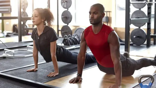Hombre y mujer haciendo yoga