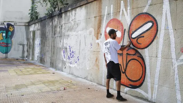 Homem grafita parede no Centrocasino 5 euro no depositSão Paulo