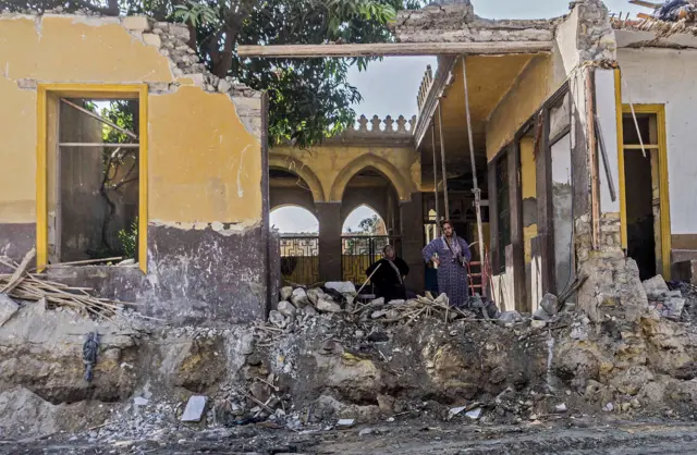 امرأة تقف في منطقة مقابر تعرضت للهدم عام 2020