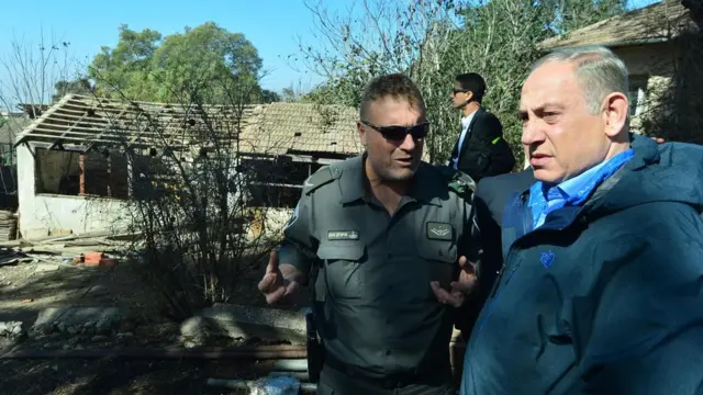 Биньямин Нетаньяху (справа) у сгоревшего дома