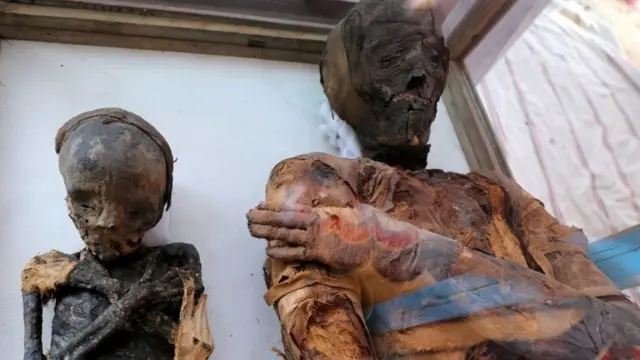 সমাধিক্ষেত্রের বাইরে প্রদর্শণ করা হচ্ছে একজন নারী ও একজন কিশোরের মমি