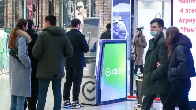 টাকা তোলার জন্য মস্কোবাসী এটিএম মেশিনের সামনে লাইন দিচ্ছে