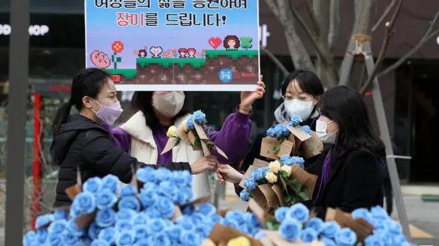 한국여성의전화 관계자들이 8일 오전 서울 광화문광장에서 세계여성의날을 맞아 시민들에게 장미 나눔 캠페인을 전개하고 있다