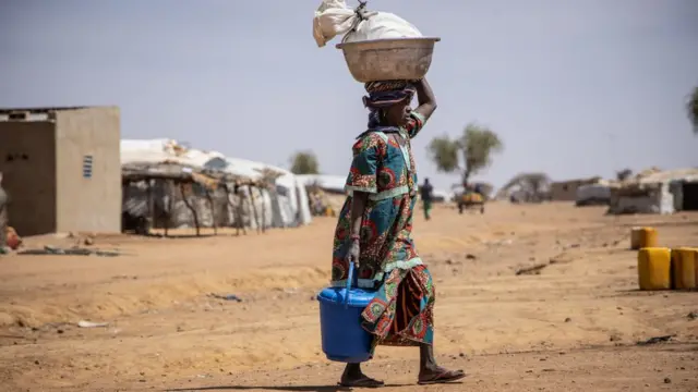 Une femme marche dans le camp de réfugiés maliens de Goudebo, à Dori, le 3 février 2020. - Plus de 8 000 réfugiés maliens vivent dans le camp de réfugiés de Goudebo.