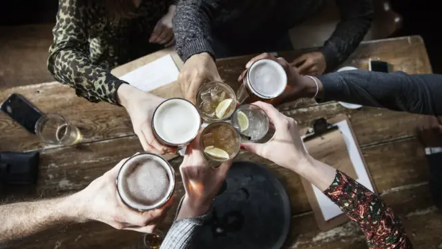 Vista aérea de varias personas brindando en un bar