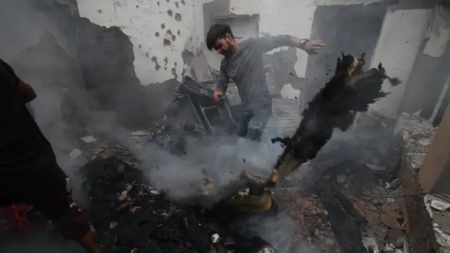 ਮੁੱਠਭੇੜ ਤੋਂ ਬਾਅਦ ਘਰ ਦਾ ਮਲਬਾ ਇਕੱਠਾ ਕਰਦਾ ਇੱਕ ਕਸ਼ਮੀਰੀ ਨੌਜਵਾਨ