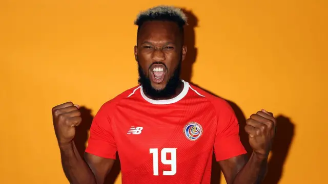 Kendall Waston con barba larga, el pelo crespo, crecido y las puntas pintadas de rubio