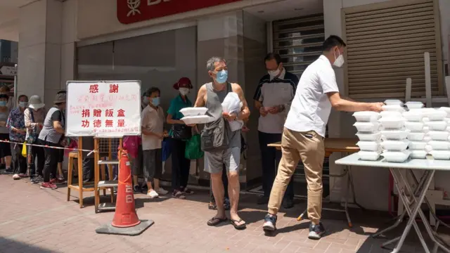 香港九龙红磡一群老年人排队领取志愿者派发的免费盒饭（11/9/2022）