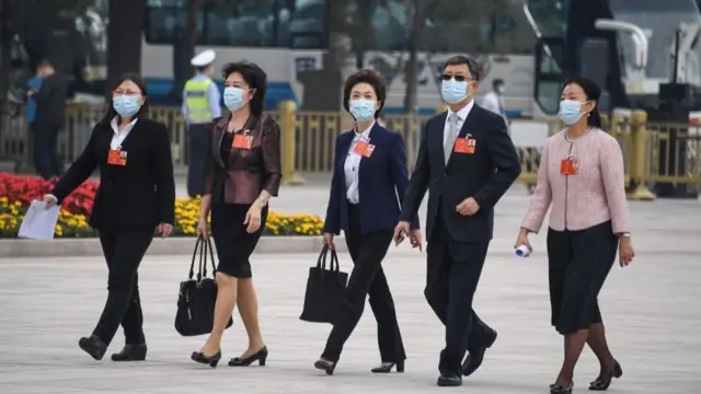 戴口罩的参会代表抵达。