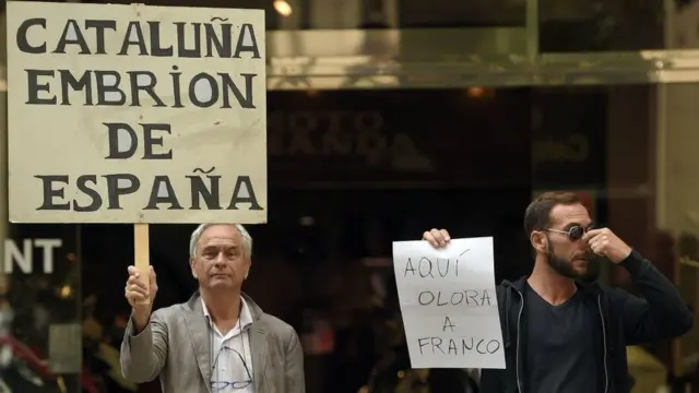 Manifestantes con carteles de "Cataluña, embrión de España" y "Aquí olor a Franco"