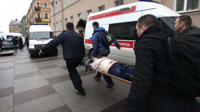 Спасатели несут на носилках пострадавшего от взрыва в питерском метро у станции "Технологгический институт"