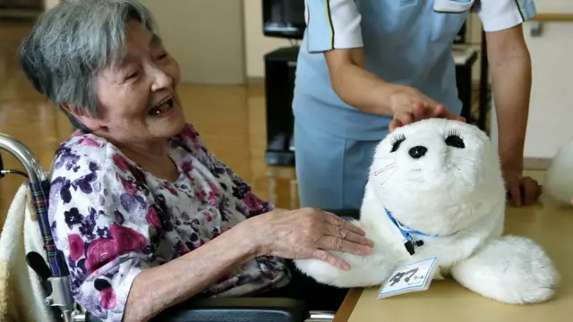 Пожилая японка с роботом Paro