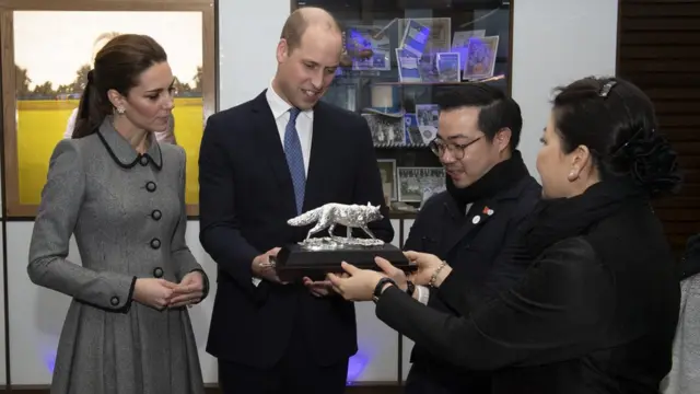 Duke of Cambridge, President of the Football Association, and Catherine, Duchess of Cambridge are given a silver fox to represent the club by Khun Aiyawatt Srivaddhanaprabha and Aimon Srivaddhanaprabha, as they visit Leicester to pay tribute to those who were tragically killed in the helicopter crash