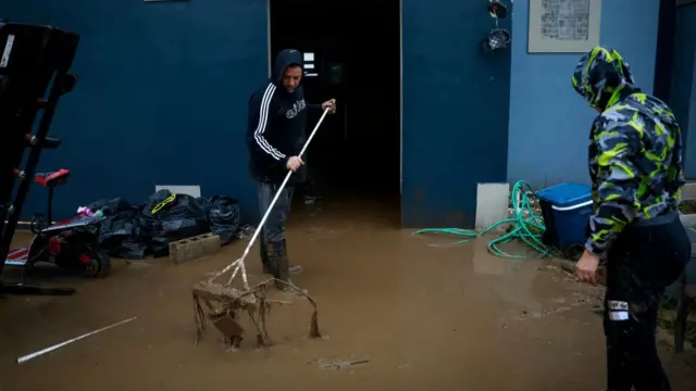 Una persona limpia el lodo en su casa
