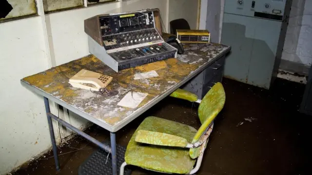 Escritorio, silla y máquina para hacer anuncios