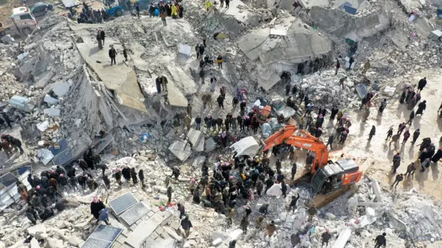 Searching for victims and survivors amidst the rubble of collapsed buildings following the earthquake in the village of Besnia near Harim in Syria