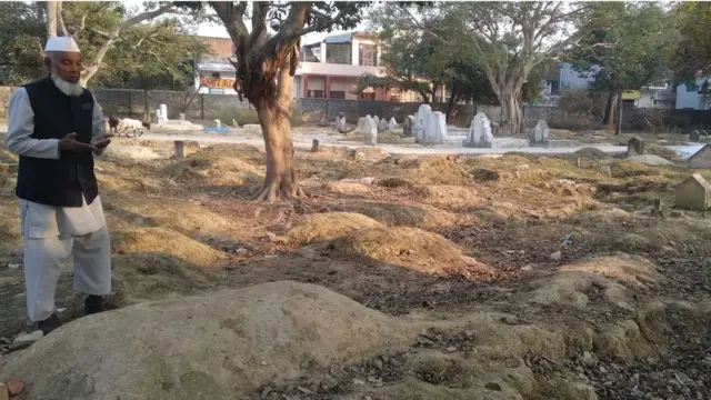 Mohammad Shareef offering prayers near a grave
