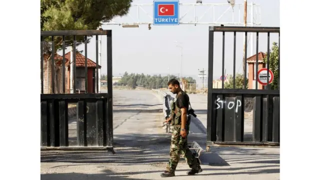 أحد عناصر الجيش السوري الحر يحرس باب السلام على الحدود السورية التركية في عام 2012