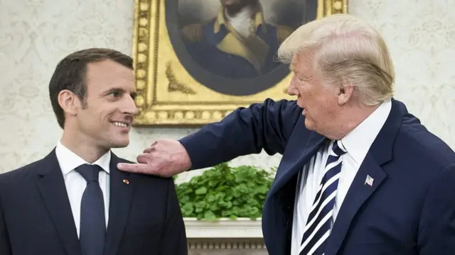 Ông Trump phủi gàu khỏi chiếc áo vest của ông Macron