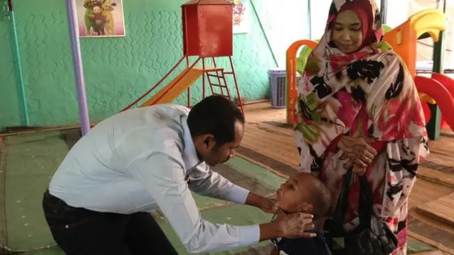 Fadil Elamin revisando a un niño.