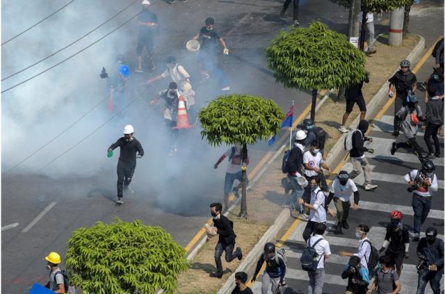 仰光民眾針對軍事政變的抗議活動中，示威者逃離警方釋放的催淚瓦斯（2021年2月28日）。