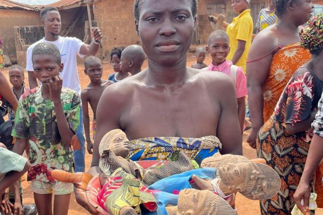 Une femme tient des figurines utilisées dans le sanctuaire des dieux jumeaux à Igbo-Ora, au Nigeria.