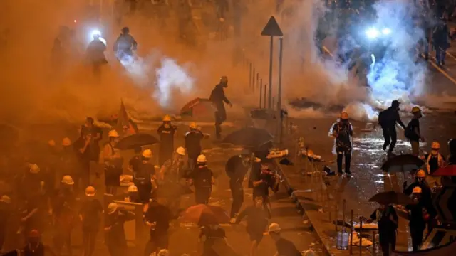 Policía disparando gas lacrimógeno.