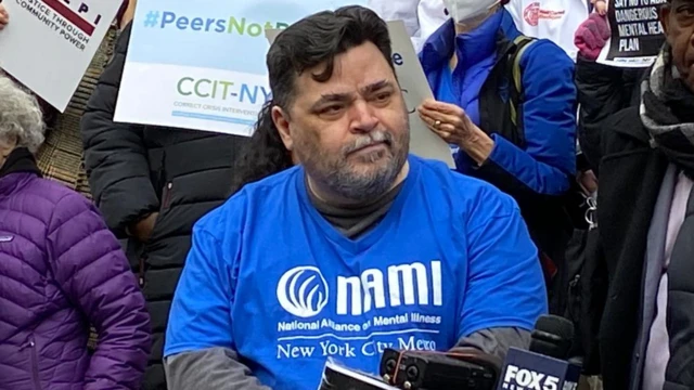 Michael observando algo em manifestação, rodeado por outras pessoas