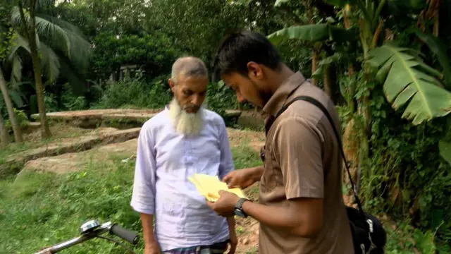 প্রাপকের কাছে চিঠি পৌছে দেয়ার কাজ করছেন একজন ডাকপিয়ন।