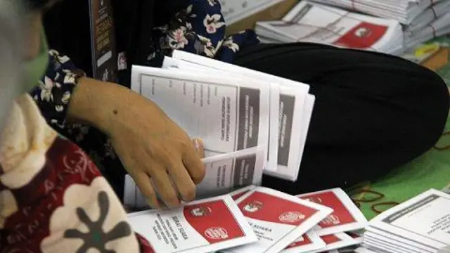 Pekerja melipat surat suara Pemilu 2024 di gudang logistik Komisi Pemilihan Umum (KPU) Dumai, di Kota Dumai, Riau, Senin (15/1/2024).