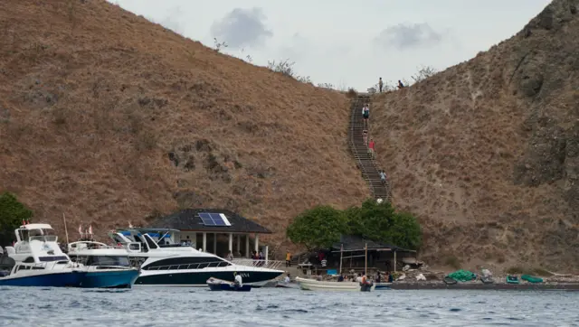 Wisatawan menuruni tangga menuju dermaga di Pulau Padar.