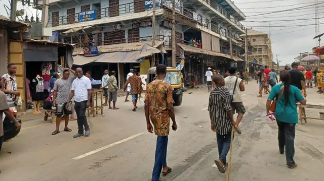 Ndị mmadụ na-akpagharị n'okporoụzọ dị n'ime ahịa Onitsha Main Market.