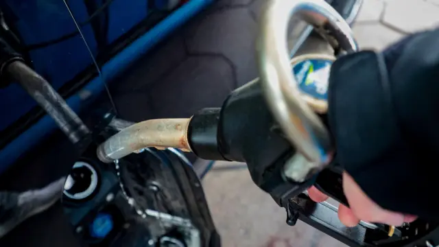 Una manguera de gasolina en un depósito del un auto