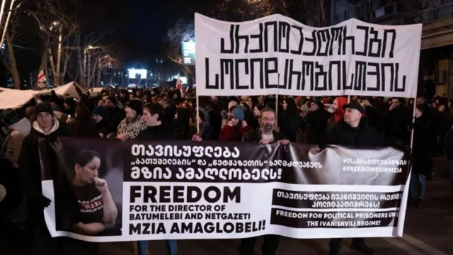 Протестующие держат транспарант с портретом Амаглобели.