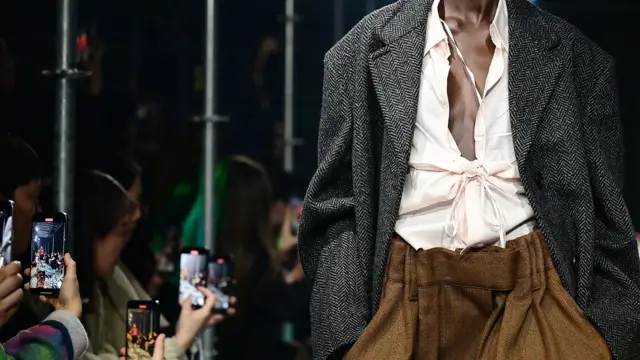 Модель на подіумі тримає руки в кишенях, видно лише тулуб, без голови та ніг