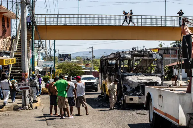 Personas rodean un autobús incendiado en una calle de Acapulco