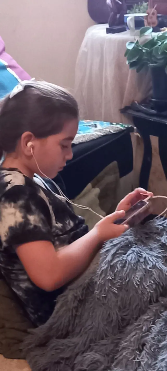 كاندي ابنة سالي. تضع سالي لابنتها "كاندي" السماعات لكي لا تسمع صوت القصف