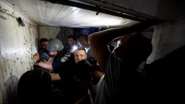 ከሮኬት ጥቃት ለመሸሽ በመጠለያ ውስጥ የተደበቁ ሰዎች 