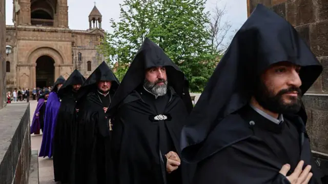 Процессия армянских священнослужителей в черных рясах 