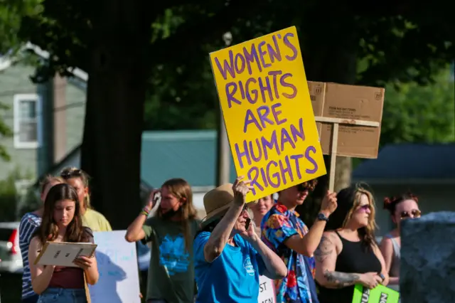 Manifestando segurando cartazb2xbet codigo promocionalque se lê: 'Direitos das Mulheres são direitos humanos' durante marcha pelos direitos das mulheres nos EUA