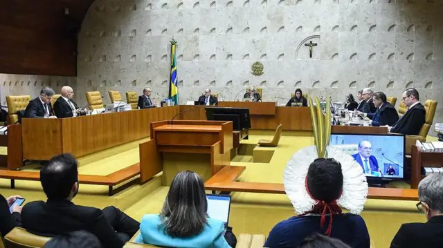 Plenário do STF reunido, com pessoas com trajes indígenas assistindo