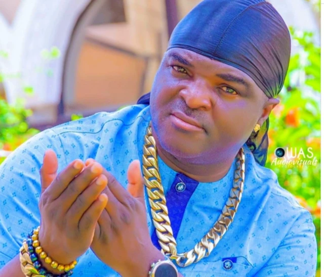 Obesere wọ aṣọ olómi aro, wọ ṣéìnì sọ́rùn, tó sì tẹ́wọ́